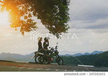 couples wearing safety helmet sitting on small enduro motorcycle against beautiful natural mountain scene at khaoyai national park thailand 107281831