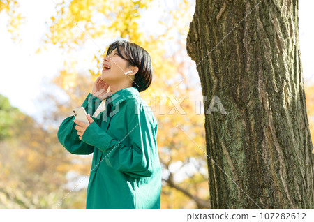 Woman enjoying music in the park 107282612