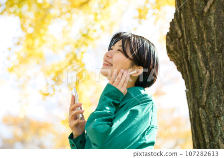 Woman enjoying music in the park 107282613