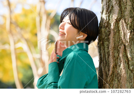 Woman enjoying music in the park Woman enjoying music in the park 107282763