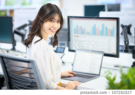 Business woman working at a desk in a bright office 107282827