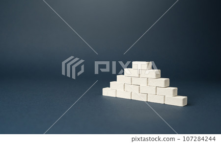 Pyramid of bricks. Pyramid with hierarchical structure. Career advancement. Achieve success and conquer new heights. Strength and solidity 107284244