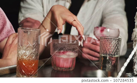Couple sits at bar counter with delicious alcohol drinks 107284535