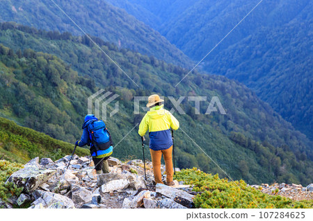 man and woman descending the ridge man and woman descending the ridge 107284625