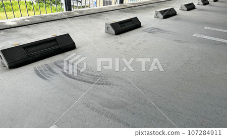 Parking lot scene (tire marks on the space of a multi-storey parking lot) Parking lot scene (tire marks on the space of a multi-storey parking lot) 107284911