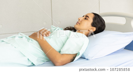 Hispanic female patient in the hospital ward. Waiting for a doctor to diagnosis and do the medical exam. Hispanic female patient in the hospital ward. Waiting for a doctor to diagnosis and do the medical exam. 107285858