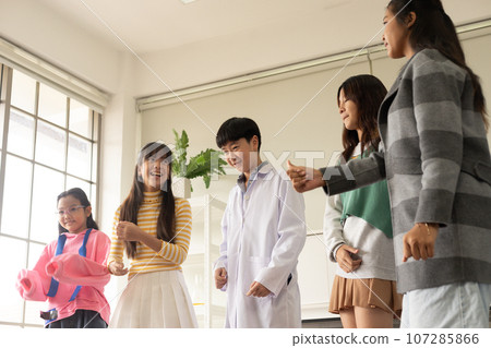 Children dancing in diverse fancy theme. Group of Asian children enjoy dancing together in the after class party. 107285866