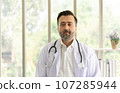 Caucasian physician portrait. Doctor with stethoscope portrait in uniform at hospital. Healthcare and medicine concept. 107285944