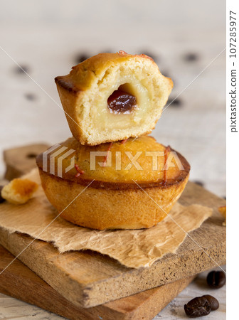 Pasticciotto leccese pastry filled with egg custard cream and sour cherry jam on a table close up Pasticciotto leccese pastry filled with egg custard cream and sour cherry jam on a table close up 107285977
