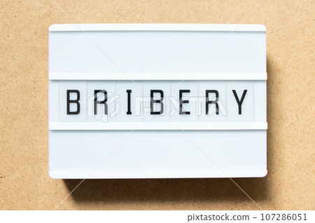 Lightbox with word bribery on wood background Lightbox with word bribery on wood background 107286051