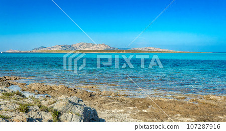 Amazing view of the Pelosa beach with the island of Asinara in the background, Stintino, Sardinia. 107287916