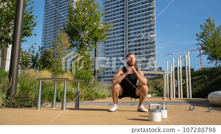 Focused millennial man doing morning sports to keep fit. Athletic man trains at the open air 107288798
