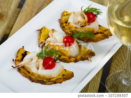 Photography of plate with sepia fried on a grill with pineapple, cherry tomatoes and sauce Chile Photography of plate with sepia fried on a grill with pineapple, cherry tomatoes and sauce Chile 107289307