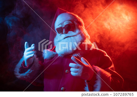 Portrait of Santa Claus in sunglasses in neon light. Portrait of Santa Claus in sunglasses in neon light. 107289765
