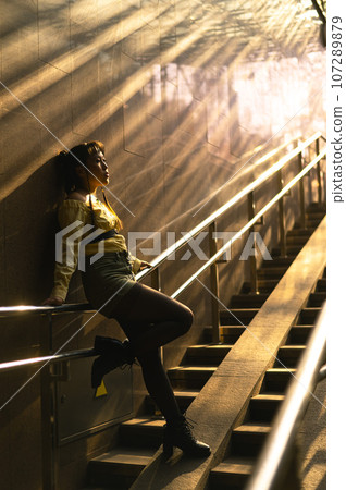Portrait of a young Asian woman posing in the subway near the stairs.  107289879