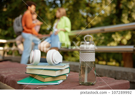 Books and copy-books stack and water bottle for refreshment selective focus Books and copy-books stack and water bottle for refreshment selective focus 107289992