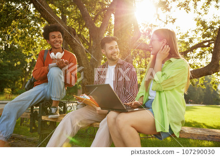 Confident smiling university students chatting together while taking rest 107290030