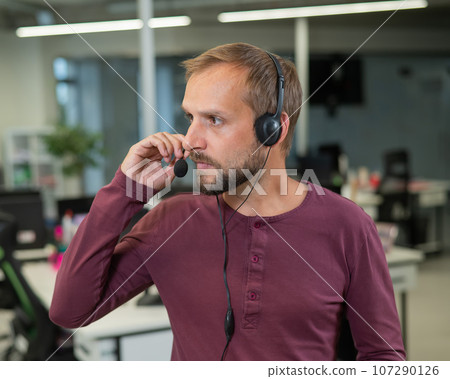 Caucasian bearded man with a headset. Male call center worker Caucasian bearded man with a headset. Male call center worker 107290126