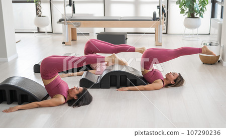 Balanced Body Pilates Arc. Three asian women exercising on pilates arc. Balanced Body Pilates Arc. Three asian women exercising on pilates arc. 107290236