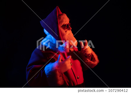 Portrait of Santa Claus in sunglasses in neon light. Portrait of Santa Claus in sunglasses in neon light. 107290412
