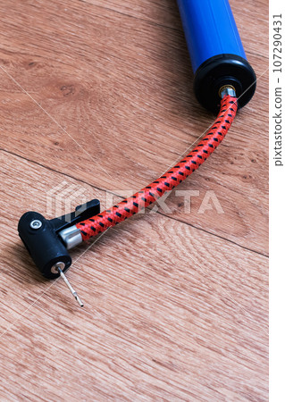 Bicycle wheel pump on wooden floor closeup Bicycle wheel pump on wooden floor closeup 107290431
