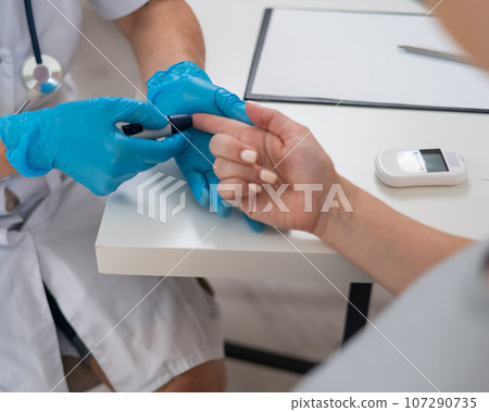 The doctor checks the blood sugar level of a pregnant patient. Gestational diabetes. The doctor checks the blood sugar level of a pregnant patient. Gestational diabetes. 107290735