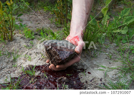 Bloodied hand with big stone Bloodied hand with big stone 107291007
