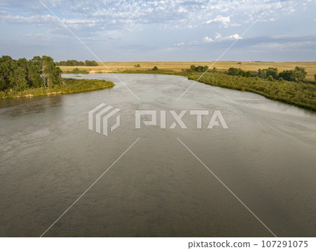 sandy, wide and shallow prairie river - Dismal River meandering through Nebraska Sandhills at Nebraska National Forest, aerial view of late summer scenery 107291075