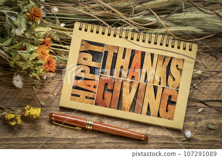 Happy Thanksgiving test in vintage letterpress wood type in a spiral notebook with floral bouquet of dry flowers and grain stalks, fall holidays concept Happy Thanksgiving test in vintage letterpress wood type in a spiral notebook with floral bouquet of dry flowers and grain stalks, fall holidays concept 107291089