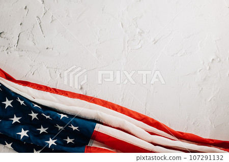 Celebrate Veteran's Day with a vintage US flag, symbolizing American honor, pride, and unity. Stars and stripes represent the government and patriotic glory. isolated on cement background 107291132