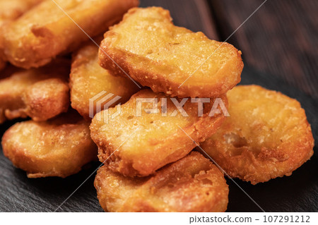 Fried chicken pieces on stone board with chopsticks - asian food close-up 107291212