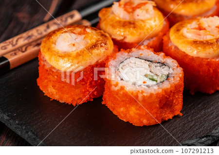 California sushi roll with crab cucumber and tobiko caviar served on black board close-up - Japanese asian food 107291213