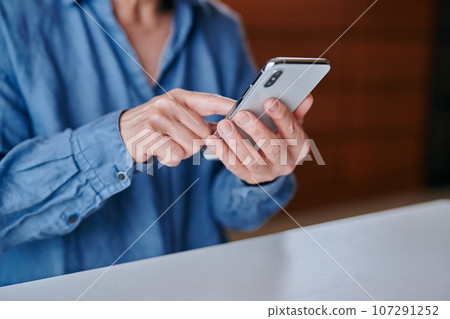 在房間裡操作智能手機的高級女性 107291252