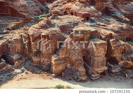 View of temples carved into sandstone rocks at daytime in Siq Gorge, Petra, Jordan. View of temples carved into sandstone rocks at daytime in Siq Gorge, Petra, Jordan. 107291330