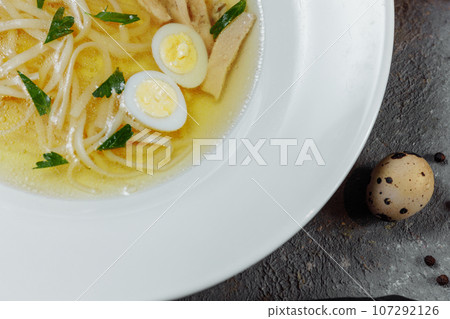Low-fat chicken broth with a half cooked egg and parsley in a glass bowl isolated on white background. Low-fat chicken broth with a half cooked egg and parsley in a glass bowl isolated on white background. 107292126