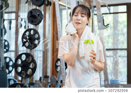 在健身房用蛋白質放鬆的女人 在健身房用蛋白質放鬆的女人 107292956