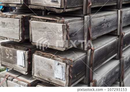 Old wooden boxes with army weapons or shells. Supply or disposal of obsolete weapons. Background. 107293153