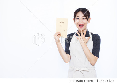 一位 30 多歲的家庭主婦在白色背景前拿著工資袋，微笑著感到驚訝 107293188