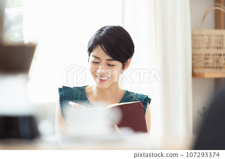 A woman looking at a notebook in the living room 107293374