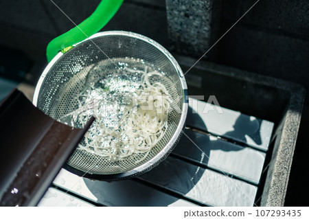Nagashi somen noodles falling into a colander 107293435