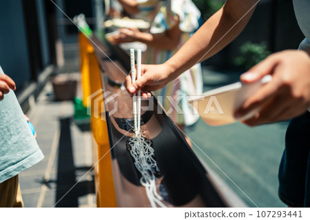 A family making somen noodles in the garden 107293441
