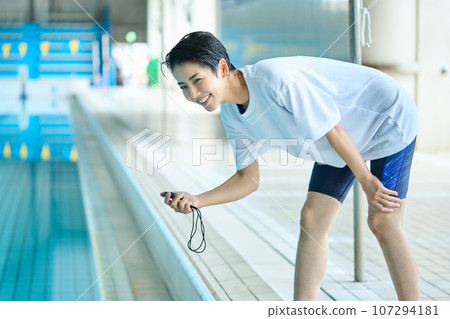 Coach checking time by the pool 107294181