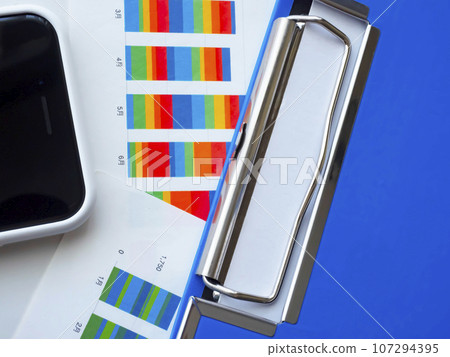 Binders, graphs and smartphones on the table 107294395