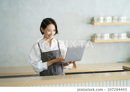 Cafe clerk with laptop Cafe clerk with laptop 107294443