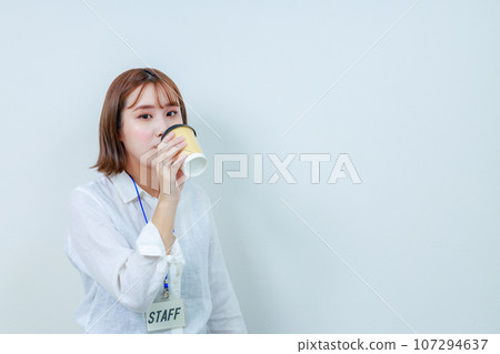 女工作人員看著相機喝咖啡 女工作人員看著相機喝咖啡 107294637