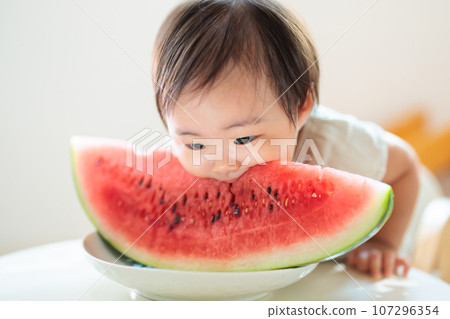 Baby bites into watermelon for the first time Baby bites into watermelon for the first time 107296354