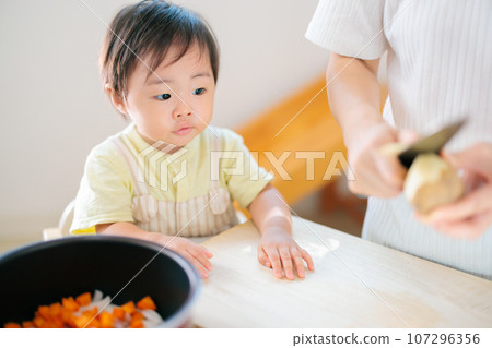 A 1-year-old baby helps with cooking with mom 107296356