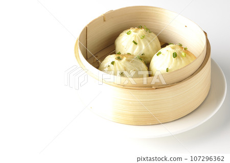 Xiaolongbao steamed in a steamer basket is photographed against a white background 107296362