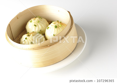 Xiaolongbao steamed in a steamer basket is photographed against a white background 107296365