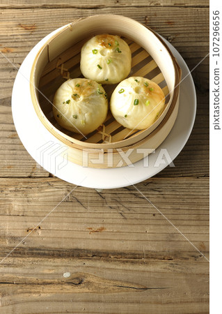 An overhead view of xiaolongbao steamed in a steamer basket 107296656